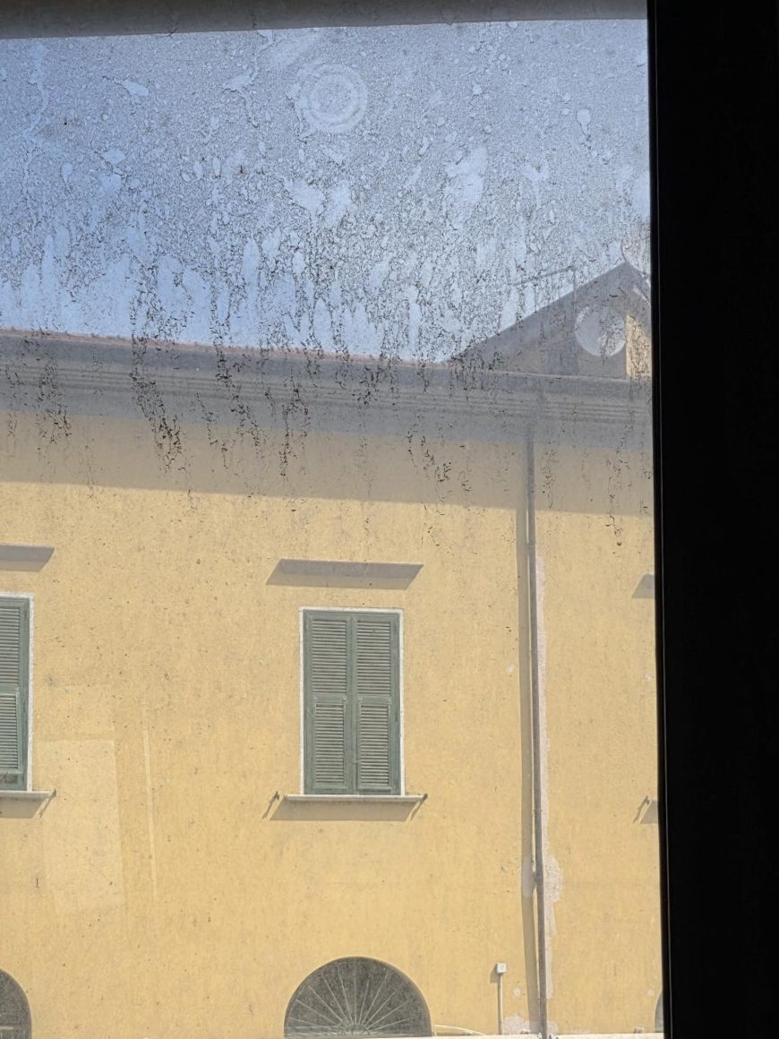 Vetro di una finestra prima della pulizia, coperto di aloni e sporco